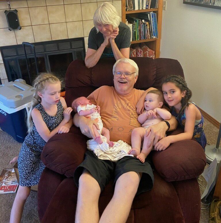 Rod Russell sits with his grandchildren